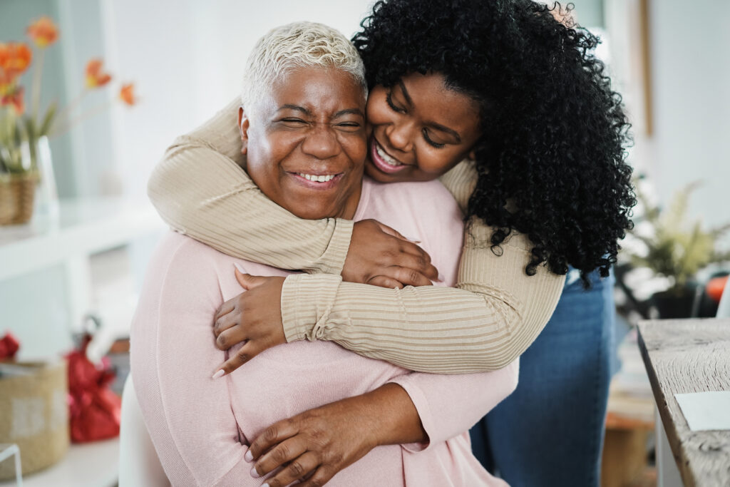 Daughter hugging smiling elderly mother