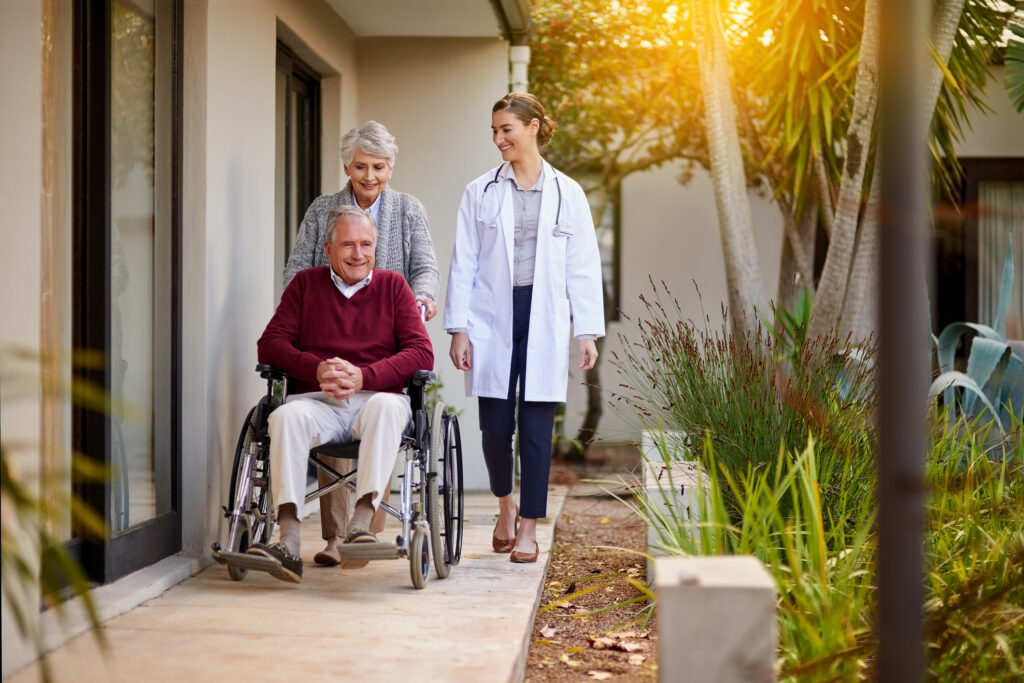 Senior couple outside nursing home with physician