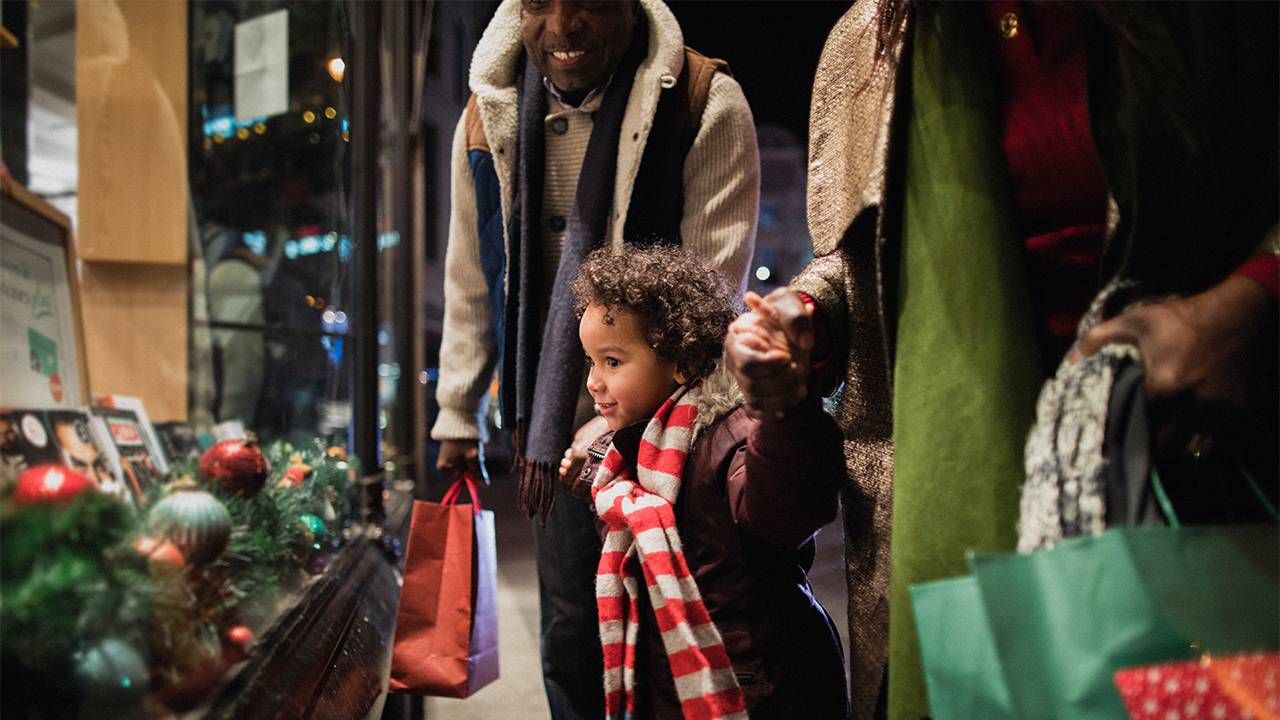 Young child looking in store holiday window