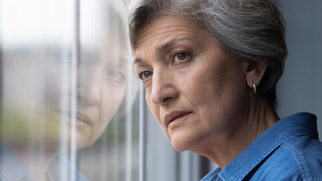 Elderly woman looking out the window