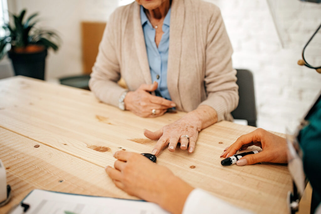 Provider sitting with elderly patient at a table