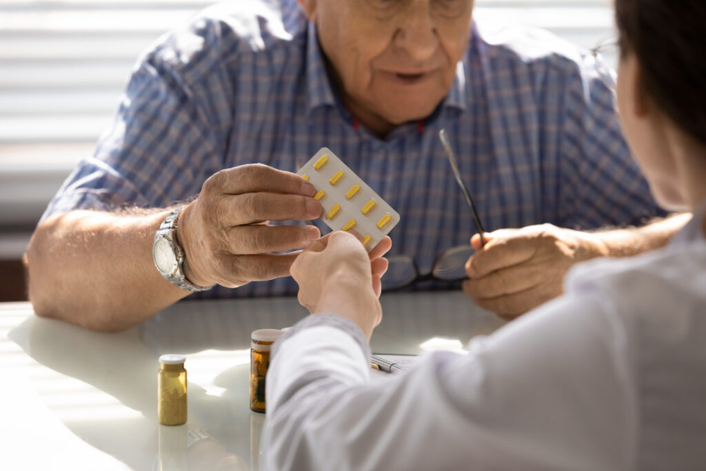 Pharmacist providing meds to elderly patient