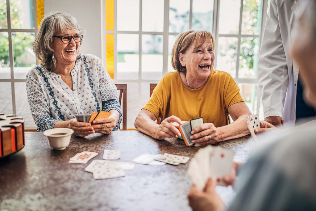 Senior women playing cards and having fun in nursing home