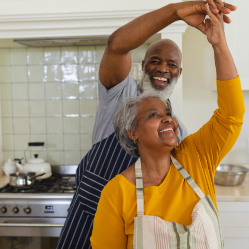 Grandparents in the kitchen with arms raised