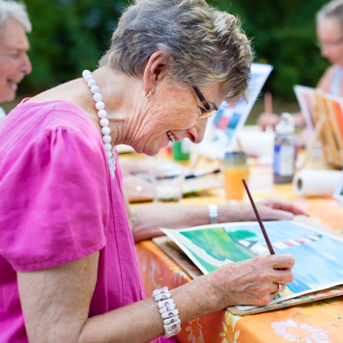 Elderly woman painting a picture